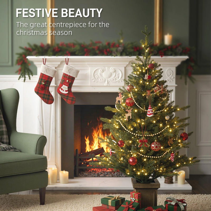 Decorated lit Christmas tree in a pot beside a fireplace with stockings