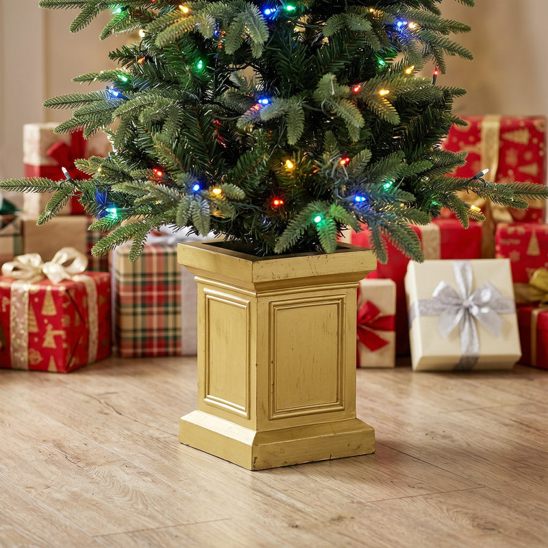 Close-up of an Aspen Fir tree with multicolour lights in a gold-tone pot beside gifts
