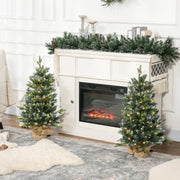 3ft set of two Christmas trees beside an electric fireplace with garland