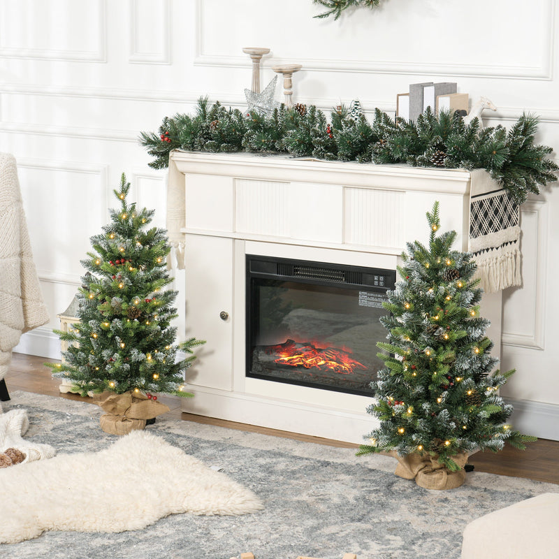3ft set of two Christmas trees beside an electric fireplace with garland