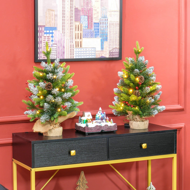 2ft pair of pre-lit Christmas trees on a console table in a red-walled room