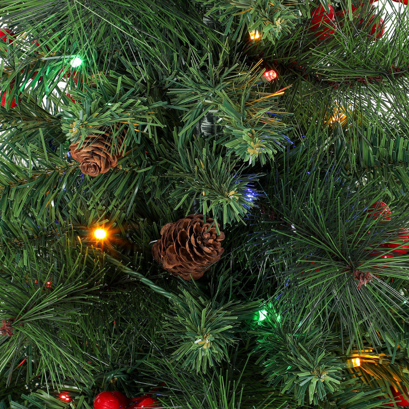 Close-up of pine needles with a pine cone, red berries and coloured lights