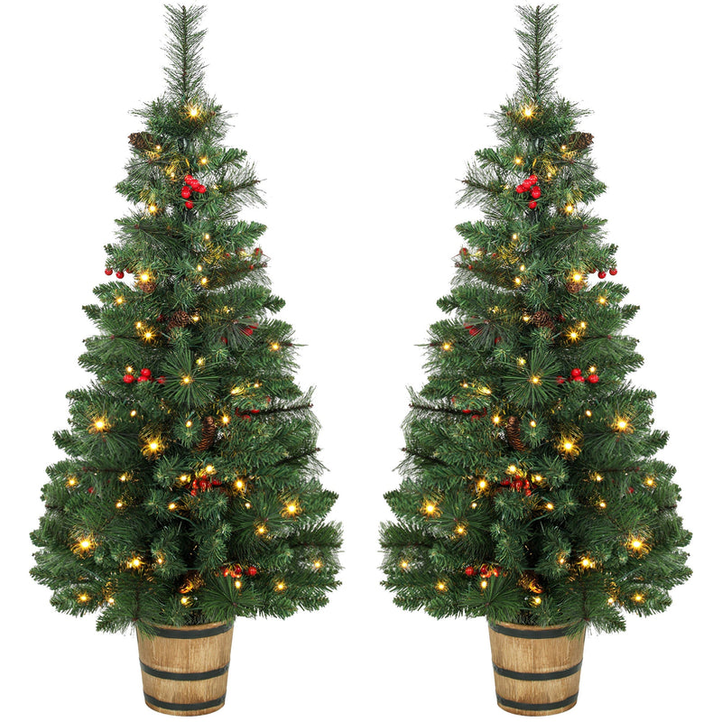 Pair of pre-lit pine Christmas trees with red berries in barrel-style pots