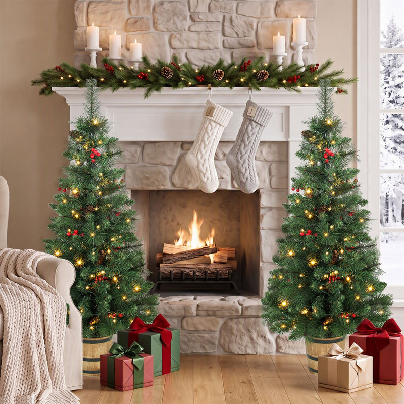 Two pine trees either side of a stone fireplace with stockings