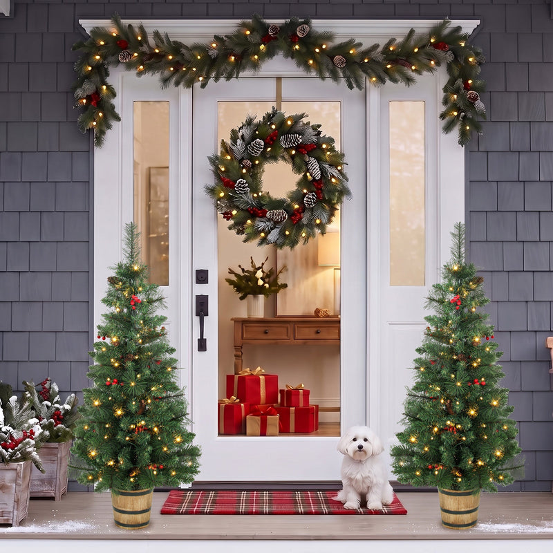 Two pine trees either side of a white front door with a garland and small dog