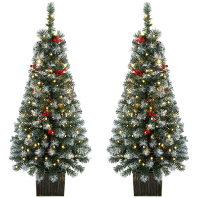 Pair of slim frosted pine Christmas trees with red berries in dark rustic pots