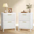 Set of 2 snow white corduroy bedside tables with gold handles, one topped with a lamp and the other with a vase