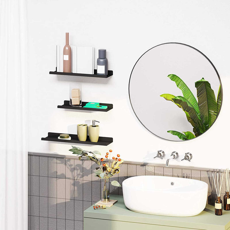 Black wall shelves mounted in a bathroom beside a round mirror and basin