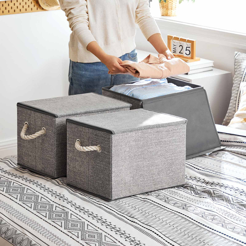 Storage boxes styled on a bedroom shelf holding clothes