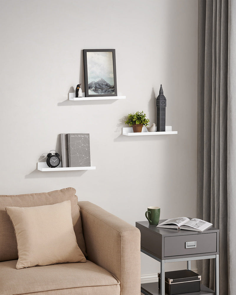 White ledge shelves on a living room wall above a beige armchair and side table