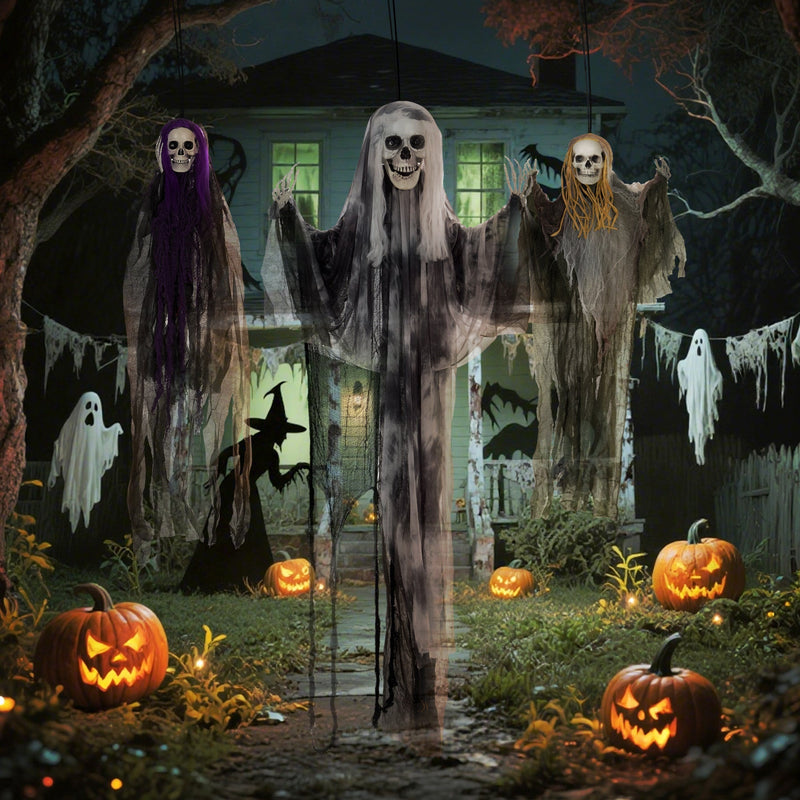 Three hanging skeleton decorations displayed in a front garden with pumpkins and witches