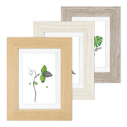 Three picture frames in light brown, white and grey wood grain finishes, each with a white photo mount