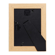 Rear view of a frame showing the black backing board, metal retaining clips and the fold-out stand