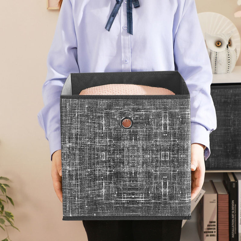 Close-up of a person carrying a fabric storage cube by its metal handle