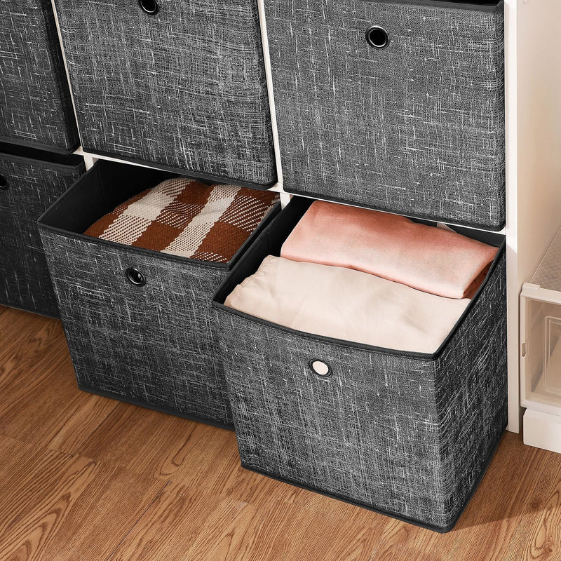 Close-up of two open storage cubes filled with folded blankets and clothing