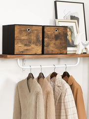 Two cubes on a wooden wall shelf above a clothes rail with coats hanging below