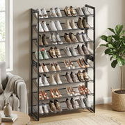 Shoe rack filled with shoes in a living room beside a cream armchair and fiddle-leaf fig