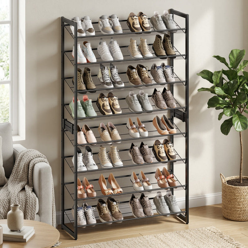 Shoe rack filled with shoes in a living room beside a cream armchair and fiddle-leaf fig