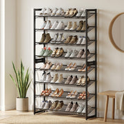 Shoe rack in a bright hallway next to a snake plant, round mirror and wooden stool