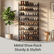 Shoe rack holding boots and brogues against a wood-panelled wall beside a potted fig tree