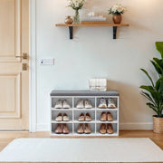 Lifestyle photo of the shoe storage bench in a hallway holding pairs of shoes in each of the 9 compartments