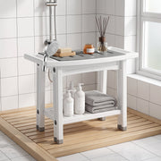 Shower stool on a wooden shower mat with toiletries and a folded grey towel on the lower shelf