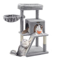 Light grey Feandrea side slope cat tree with one cat in the condo and one on the scratching ramp