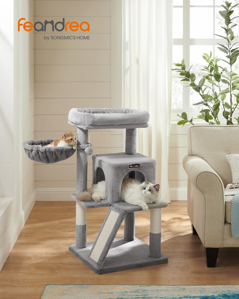 Feandrea by Songmics Home cat tree in a living room with cats on the platform and in the swing basket