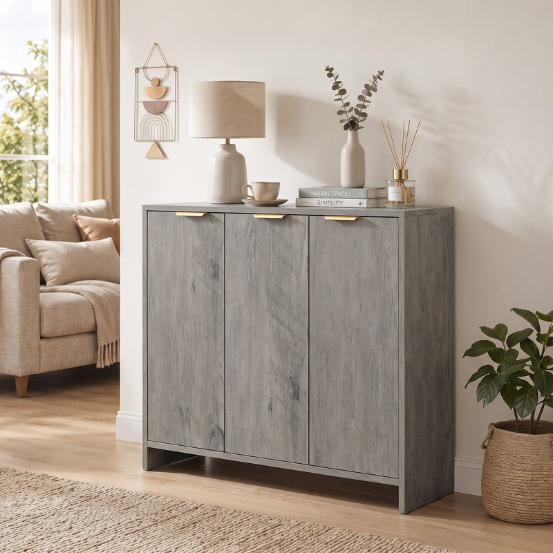 Grey sideboard in a living room with a table lamp, vase and books on top