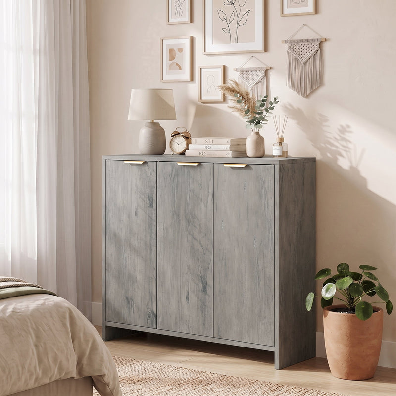 Grey sideboard in a bedroom with a lamp, alarm clock and reed diffuser on top