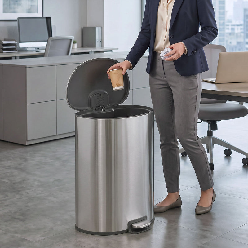 Office worker dropping a coffee cup into the open silver pedal bin