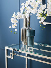 Console table styled with a lamp and vase in a bright foyer