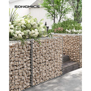 Stone-filled gabion cages used as a raised planter wall in a garden