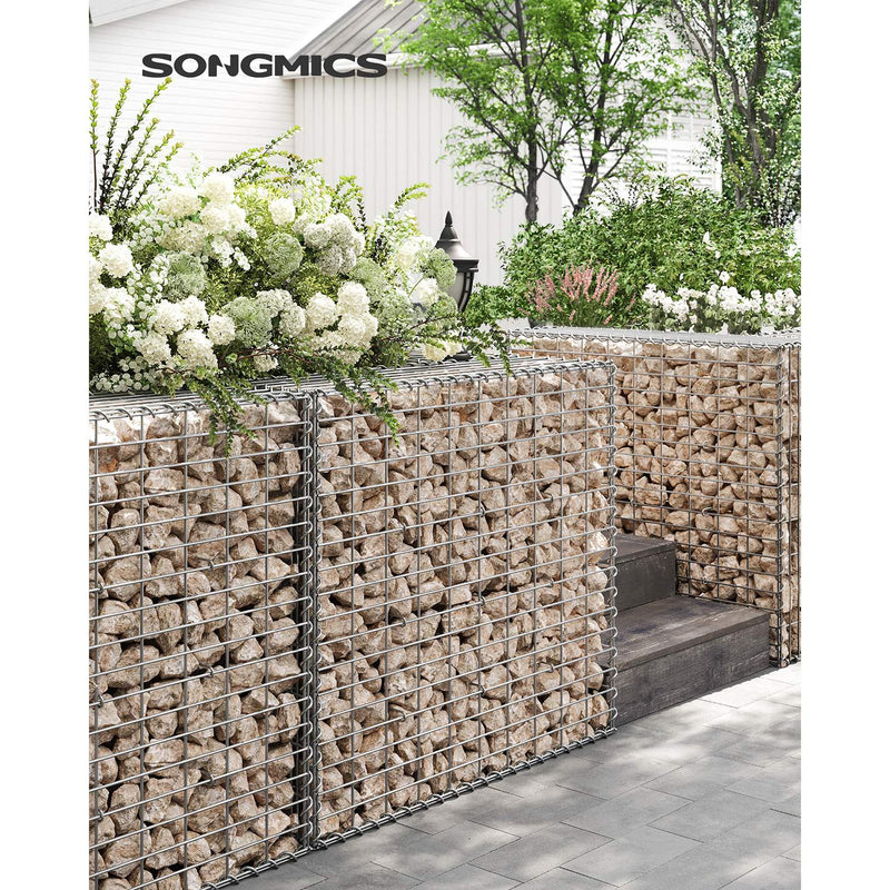 Stone-filled gabion cages used as a raised planter wall in a garden
