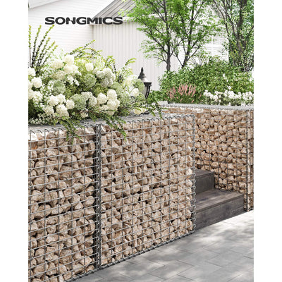 Stone-filled gabion cages used as a raised planter wall in a garden
