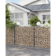 Stone-filled gabion wall running alongside a house exterior