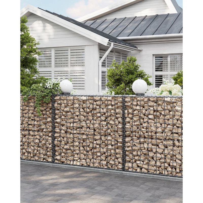 Stone-filled gabion wall running alongside a house exterior