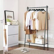Garment rack in a hallway beside a white shoe cabinet with an umbrella and woven rug