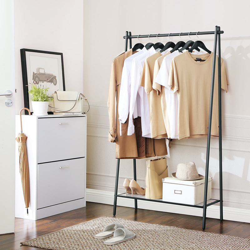 Garment rack in a hallway beside a white shoe cabinet with an umbrella and woven rug