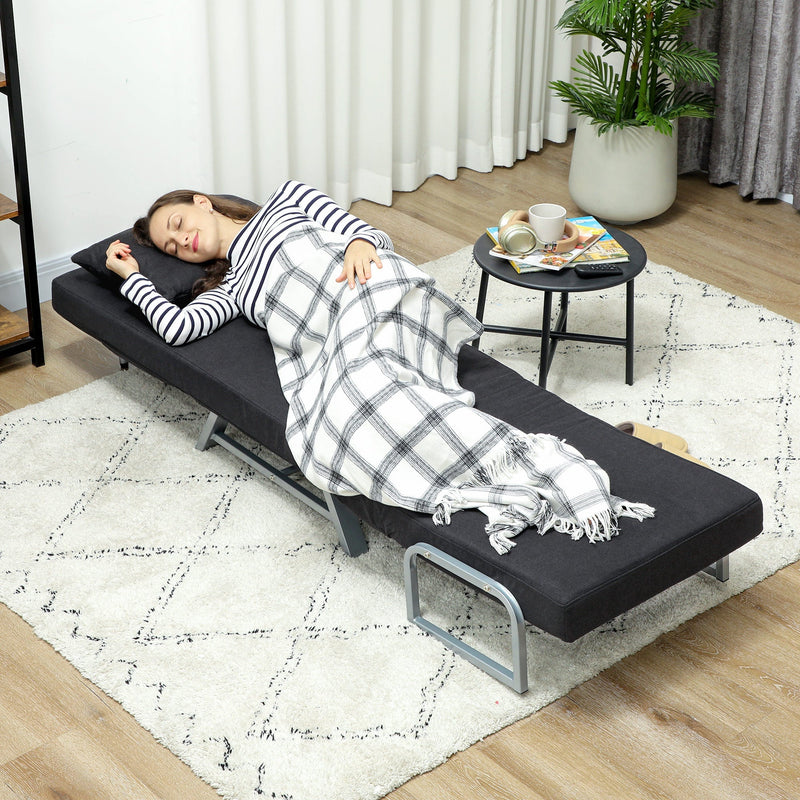 Chair bed folded flat into bed mode with pillow on a wooden floor