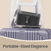 Slate grey jewellery case packed inside a clear toiletry bag on top of a suitcase next to sunglasses, illustrating its compact travel size