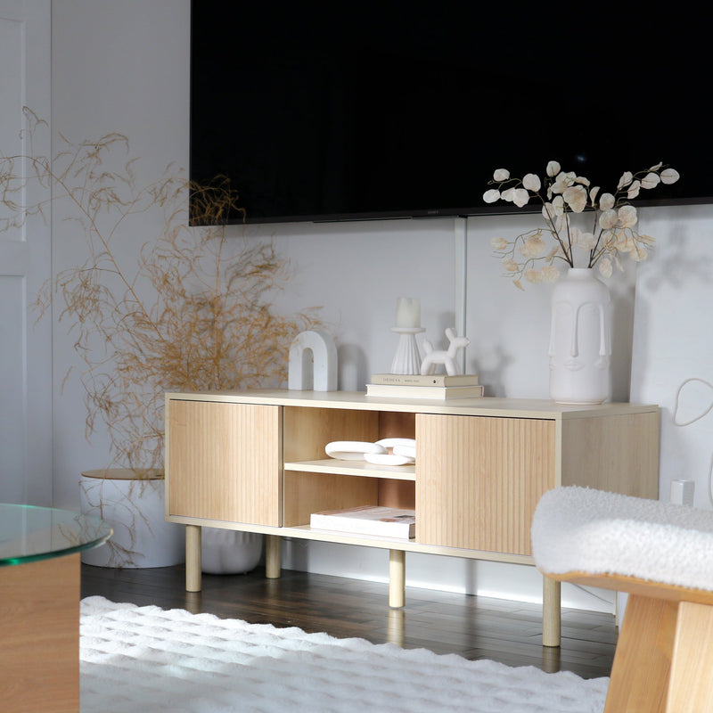 Lifestyle photo of the TV cabinet styled in a modern living room with a wall-mounted TV above it