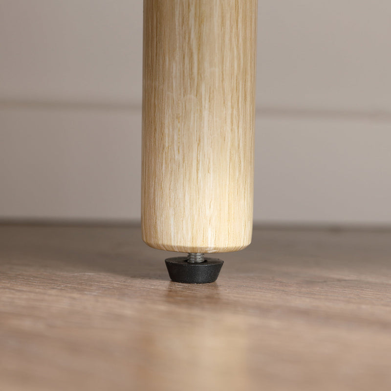 Close-up of the cabinet's adjustable levelling foot on a wood floor