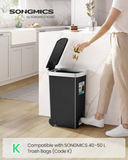 Person stepping on the pedal of a black 40L kitchen bin to drop food scraps in