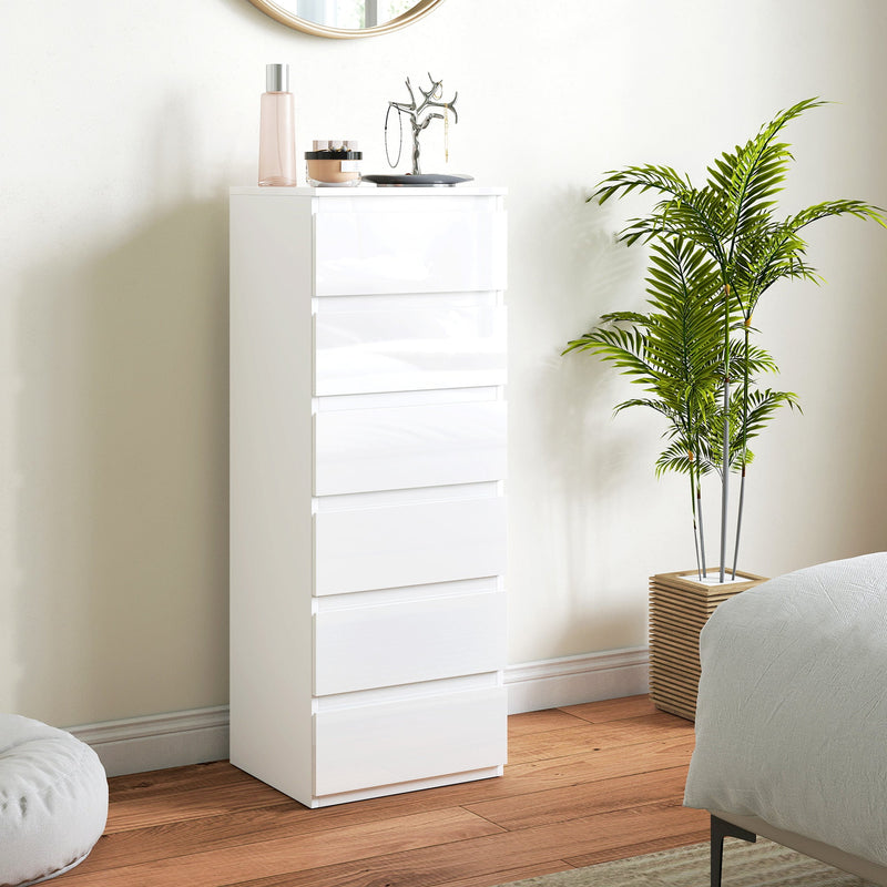White 6-drawer chest of drawers in a bedroom beside a potted palm and a mirror