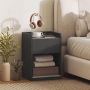 Bedside table styled next to a bed with headphones, a coffee cup and books on top