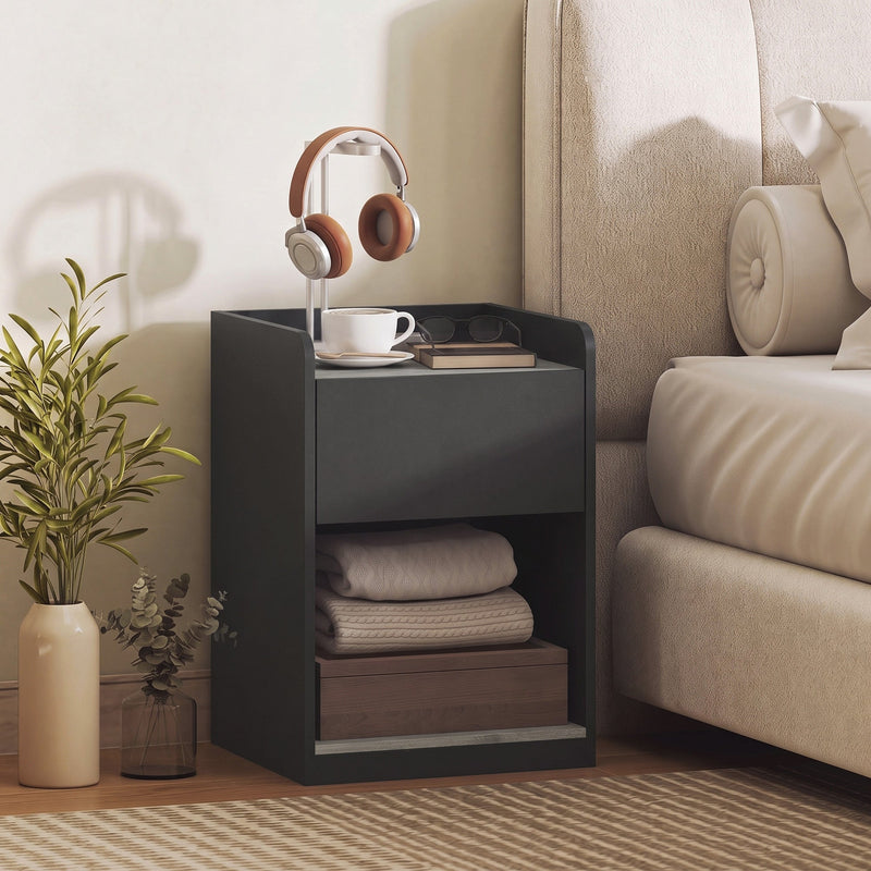 Bedside table styled next to a bed with headphones, a coffee cup and books on top