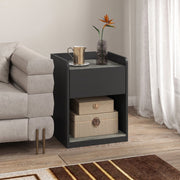 Bedside table in a living room setting with a jug, vase and flowers on top