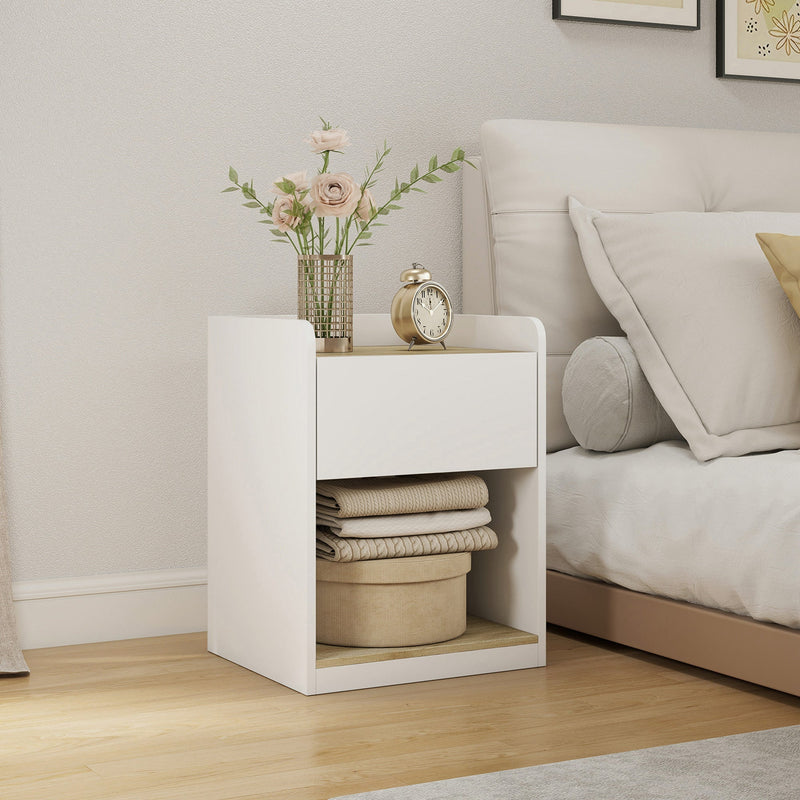 White and oak bedside table with flowers and a clock displayed on top, beside a bed