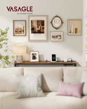 Vasagle console table behind a cream sofa with a table lamp, photo frame and gallery wall